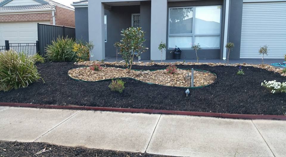 Front garden bed finished with black mulch and defined shape